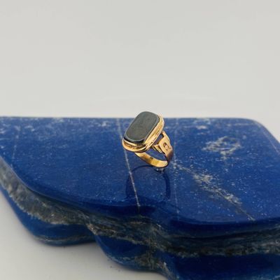 a picture of a gold ring with a black stone on it