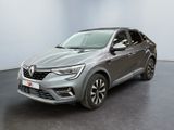 Une voiture grise est garée dans une pièce aux murs blancs.