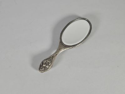 Miroir face à main en métal argenté repoussé d'une femme parmi des fle - Photo 1