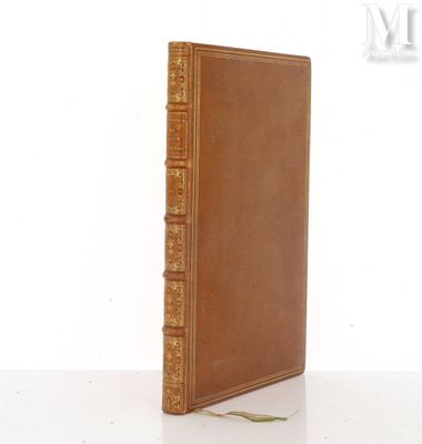 un vieux livre à la couverture marron posé sur une table blanche