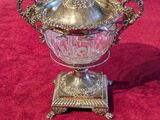 an antique silver plated bowl with a lid on a stand