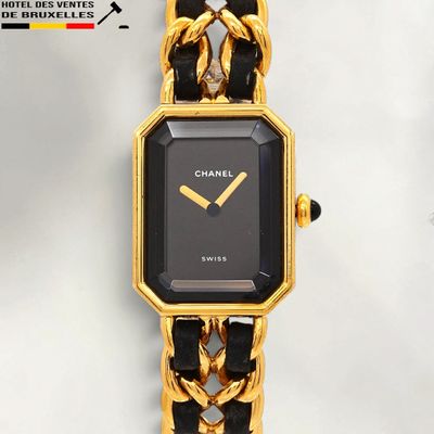 a black and gold watch with a chain around it