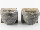 pair of gray stone urns with handles on a white surface