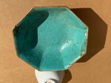 a blue bowl with a white handle on a brown surface