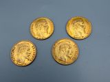 four gold sovereigns on a blue surface