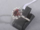 an image of a ring with a red stone surrounded by white diamonds