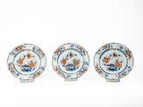 trois assiettes bleues et blanches ornées de fleurs orange