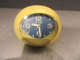 une horloge jaune posée sur un comptoir