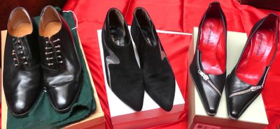trois paires de chaussures noires dans une boîte posée sur un tissu rouge