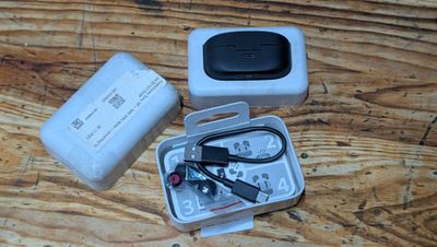 a box with a remote control and a charger on a wooden table