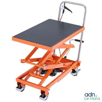 une paire de ciseaux orange posée sur un socle métallique