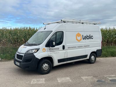 une camionnette blanche garée sur un parking à côté d'un champ de maïs