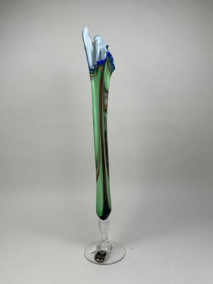 un vase en verre dans lequel se trouve une fleur bleue