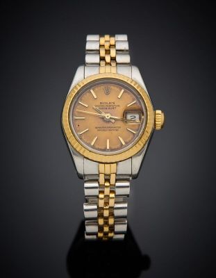a close up of a watch on a black surface with a black background
