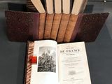 several old books are stacked on top of each other on a table