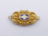 a close up of a gold and blue broocher on a white surface