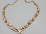 a gold necklace with pearls on a chain