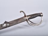 an old sword with a metal handle on a white surface