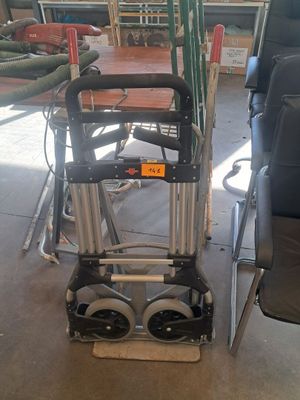 a chair that is sitting next to a hand truck