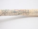 a baseball bat with a drawing on it sitting on a table