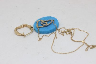 Deux bijoux sont posés sur une surface blanche