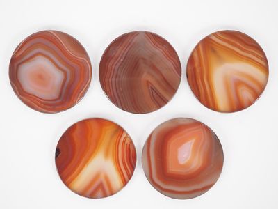 six agite coasters on a white surface with a white background