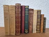 several old books are lined up on a wooden table