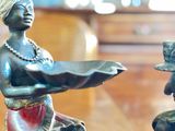 a statue of a woman holding a bowl and a man holding a bowl