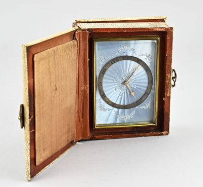 a small clock inside of a wooden box on a white surface