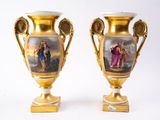 une paire de vases en or décorés de peintures, posés sur une table