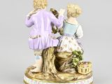 two figurines of a couple sitting on top of a tree