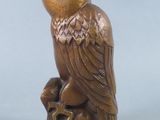 an image of a statue of a bird sitting on a tree stump