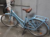 a blue bicycle parked next to a wall in a parking garage