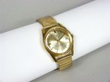 une photo d'une montre en or posée sur une serviette de table