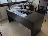 un bureau avec un ordinateur et une chaise dans une pièce