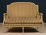 an image of a striped couch in a room with a blue wall