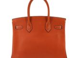 a brown leather handbag on a white background