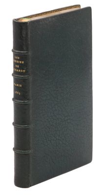 un vieux livre à la couverture noire posé sur une surface blanche