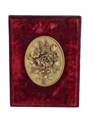 boîte en velours rouge ornée d'un médaillon doré représentant des fleurs