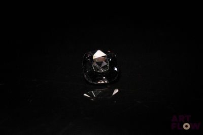 un gros plan d'un diamant noir sur une surface noire