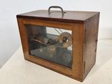 a small wooden box with a clock inside of it