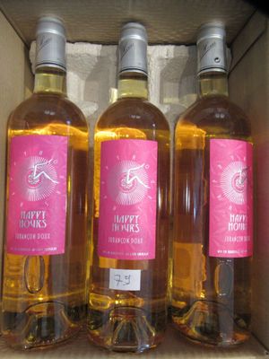 trois bouteilles de vin rosé sont posées dans une boîte sur une étagère