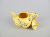 yellow teapot with a lid and flowers on it