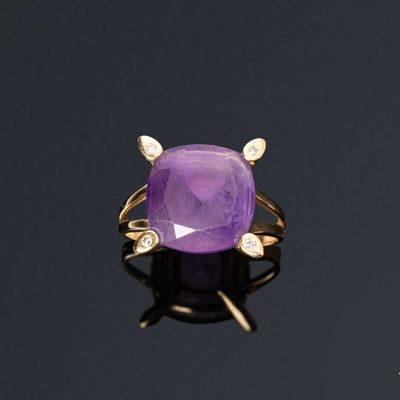 une bague en améthorate et diamant posée sur une surface noire