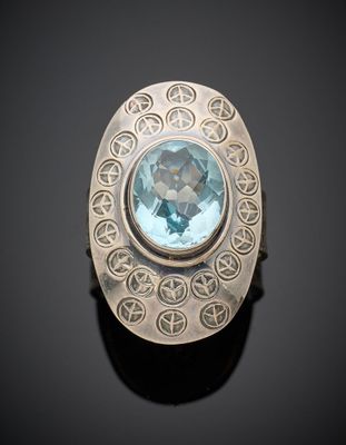 un gros plan d'une bague en argent sertie d'une topaze bleue
