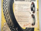 une vieille affiche représentant un pneu accrochée au mur, avec l'image d'un pneu
