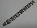 gros plan d'un bracelet métallique sur une surface blanche