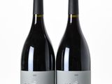 two bottles of wine sitting next to each other on a table