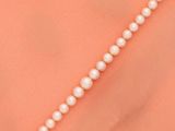 un gros plan sur un collier de perles au cou d'une femme