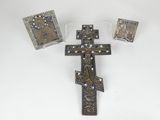four pieces of metal and glass with a cross on a white surface